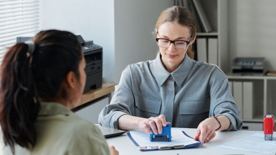 (In the image an immigration solicitor can be seen approving a temporary work visa UK) UK 2-Year Temporary Work Visa Complete Application Process