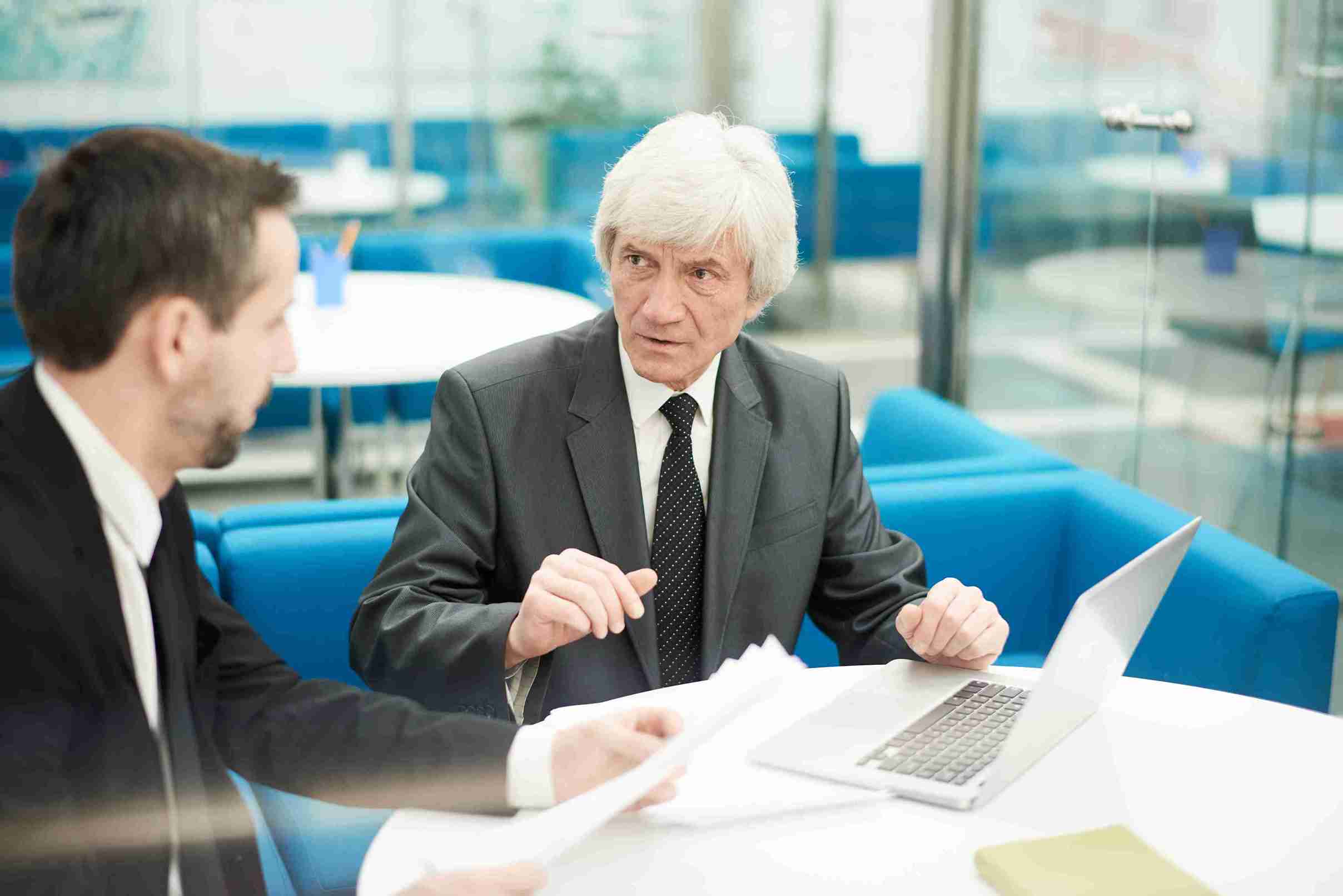 Senior solicitor discussing with his assistant the new compliance and obligations 