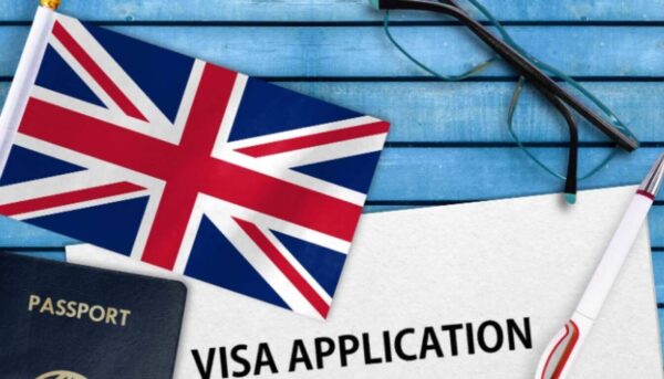 Passport, UK flag, and paperwork that reads "VISA APPLICATION," symbolizing the UK visa process.