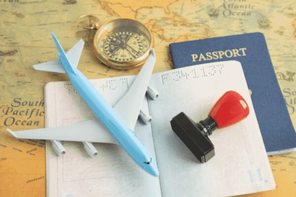 Passport, flight, and approval stamp, symbolising the journey and new restrictions under the UK's updated immigration policy