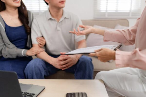 (A couple reviewing proof of relationship documents UK with a professional advisor to prepare for the genuine relationship test UK.)