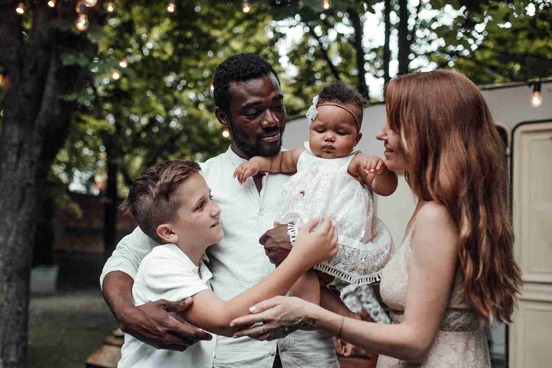 A happy family with a baby, featuring two smiling adults, enjoying a moment together.
