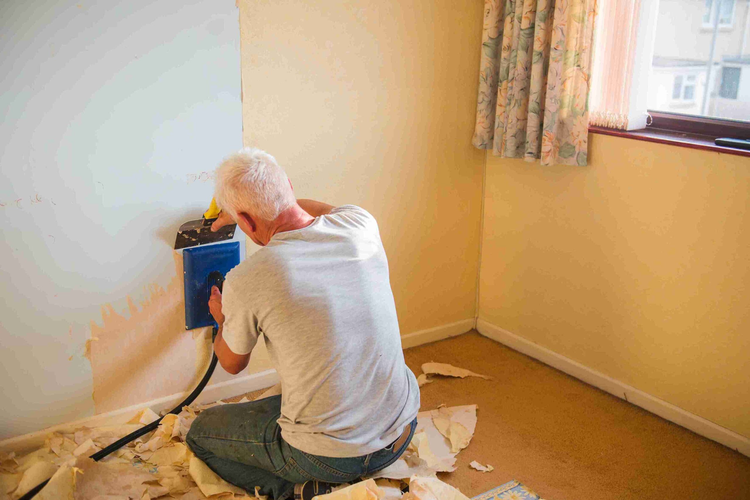 A man uses a power tool to cut paper, illustrating a hands-on approach to housing disrepair claims.