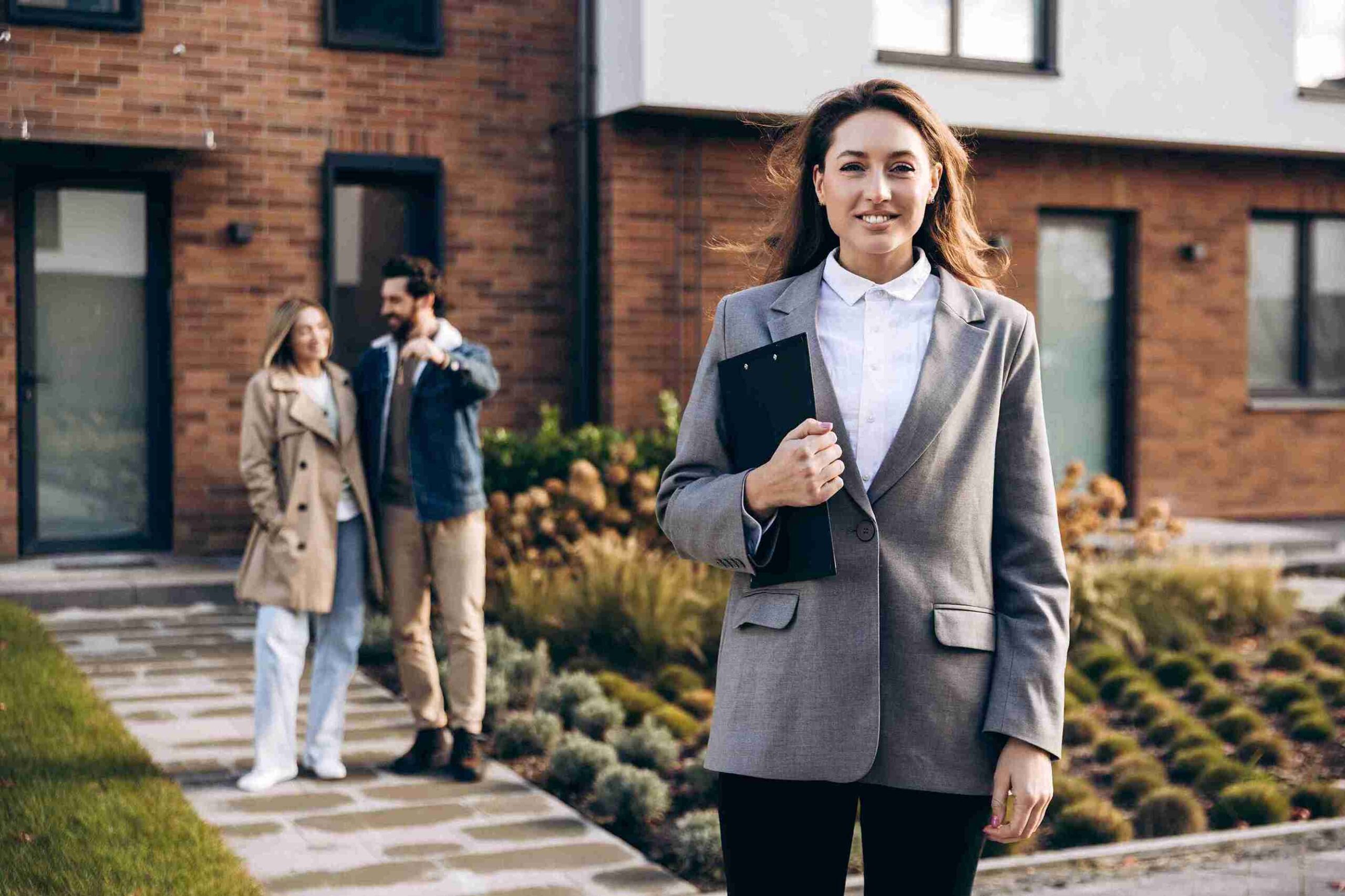 A woman in a business suit stands confidently in front of a house, representing expert UK property solicitors guiding clients.