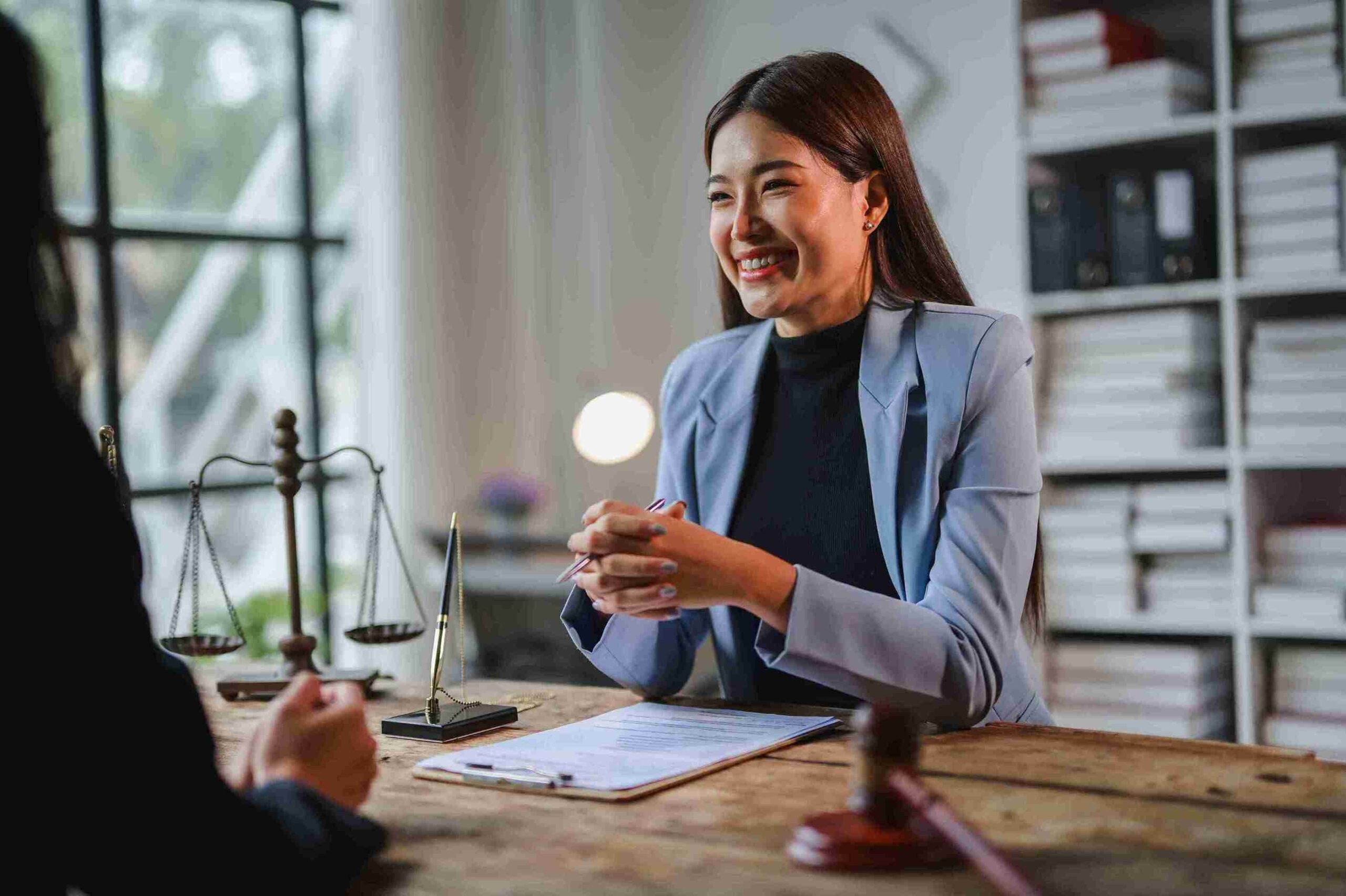 A woman in a business suit engages in conversation with another woman, both appearing focused and professional.