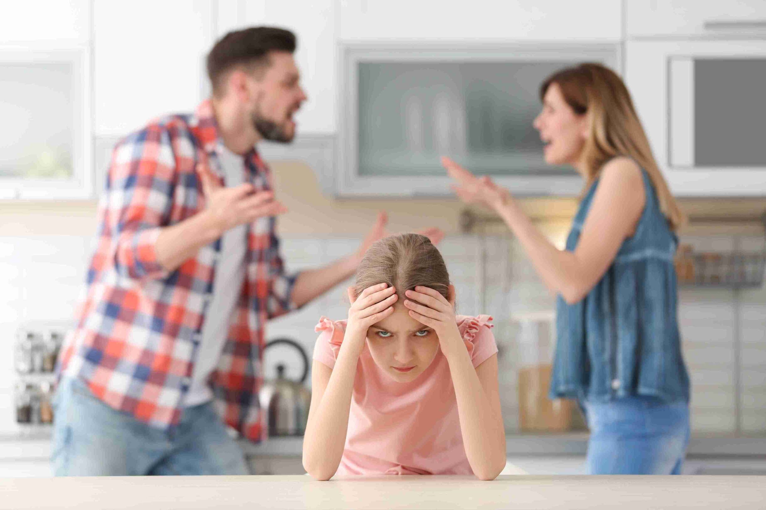 A young girl sits on the counter with her parents, highlighting a moment of family togetherness amid domestic violence awareness.