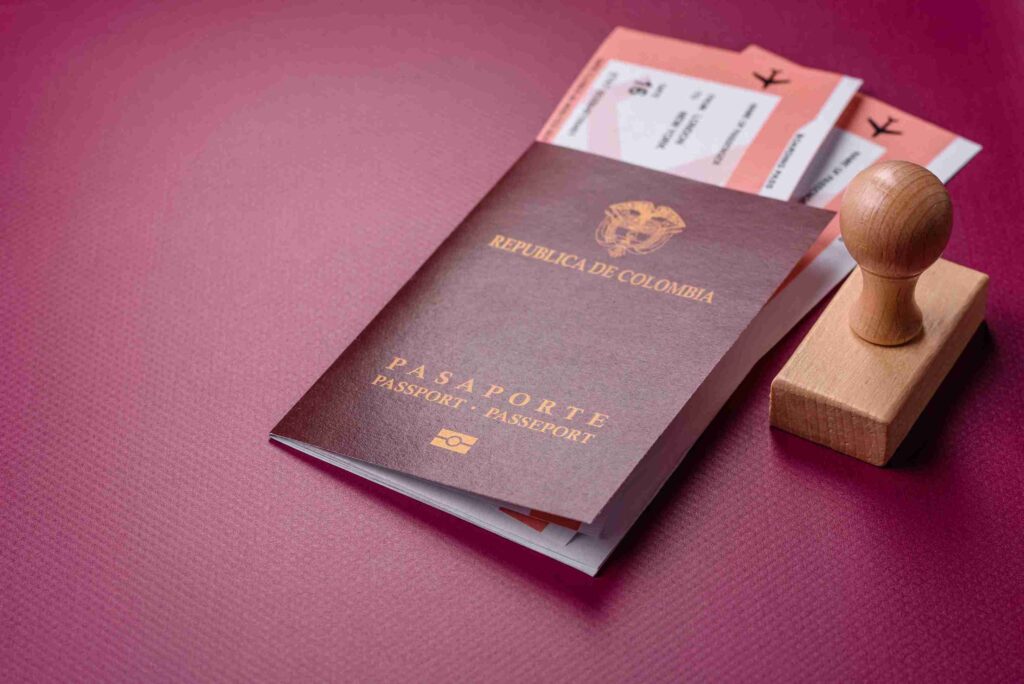 A UK passport with flight tickets and a wooden stamp on a textured purple background, representing spouse visa.