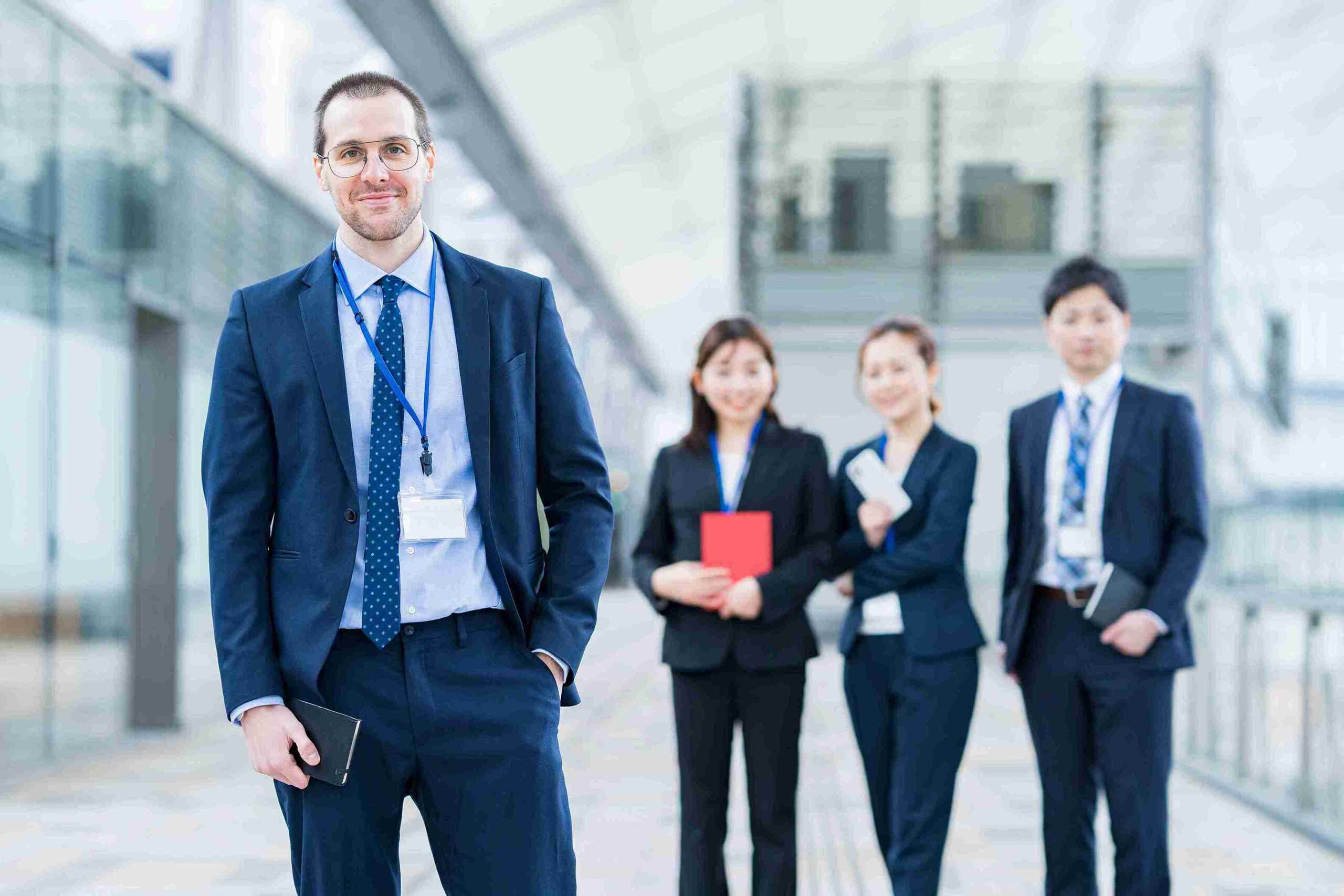 Professional man in suit with colleagues in background, representing Employment Law UK governing workplace rights, compliance, and disputes.