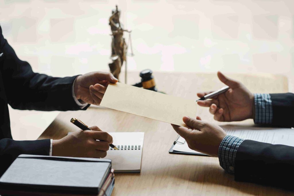 Two men in suits discuss urgent appeals at a table, client giving an application to lawyer enforced immigration removal.