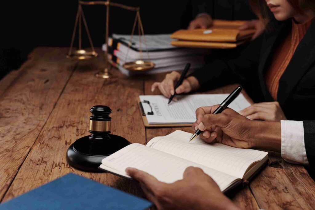 Professionals reviewing documents with gavel and scales, representing liaison with family court and compliance with UK family law for fair outcomes.