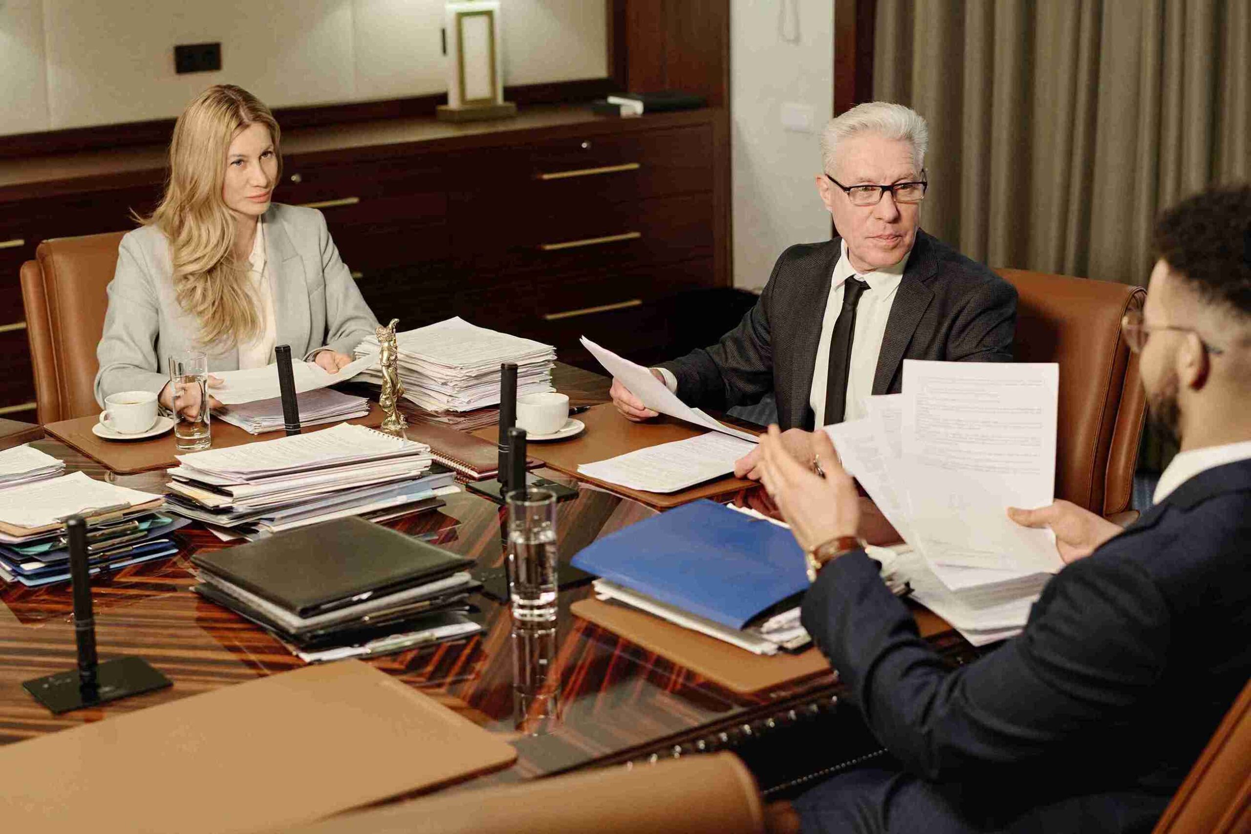 A group of judicial review engaged in discussion around a conference table, focusing on legal matters and decision processes.