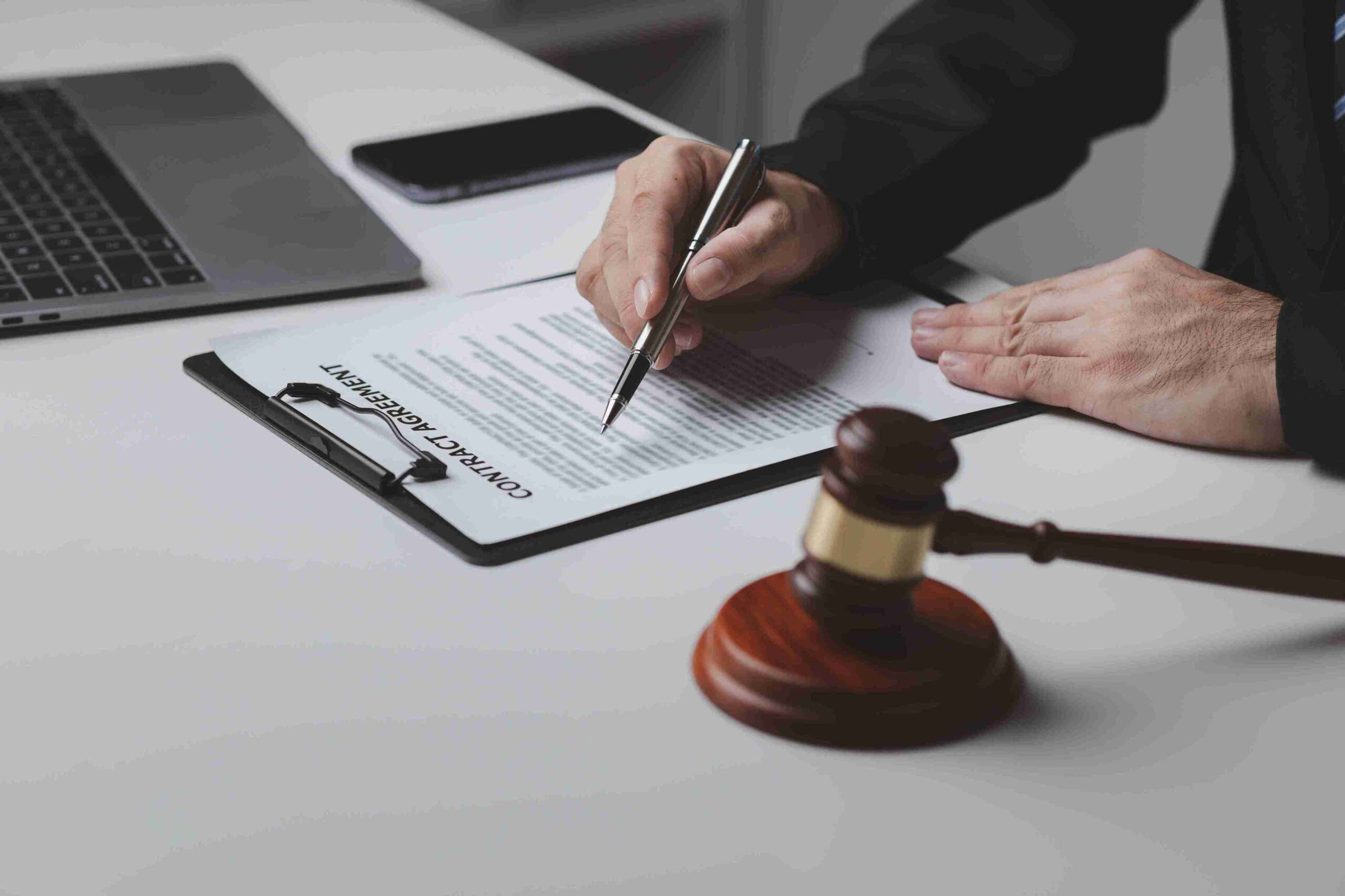 Person specialist legal support with laptop and gavel,signing documents of immigration bail and release from detention.
