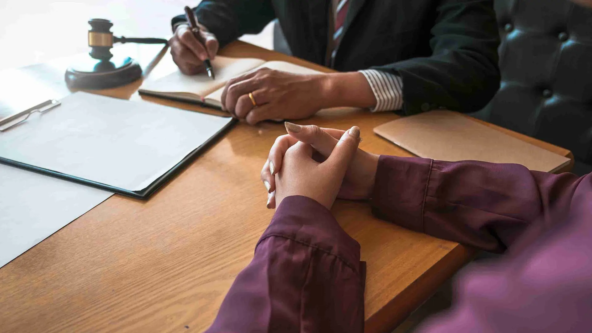 A lawyer assists a client at a desk, discussing legal help for applying without visa fees due to limited funds.