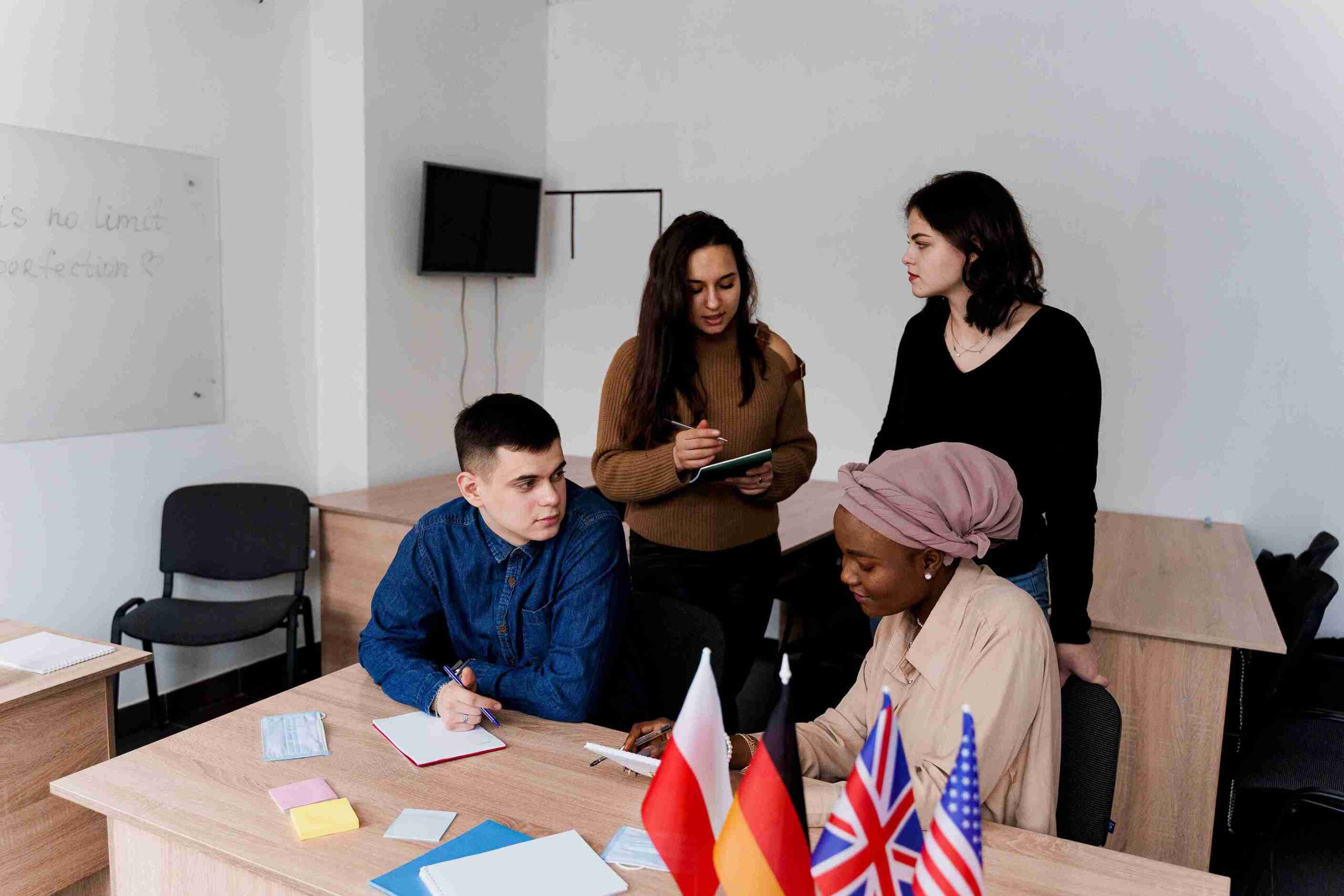 A diverse group of people in an office, discussing visa appeals with flags representing different countries in the background.