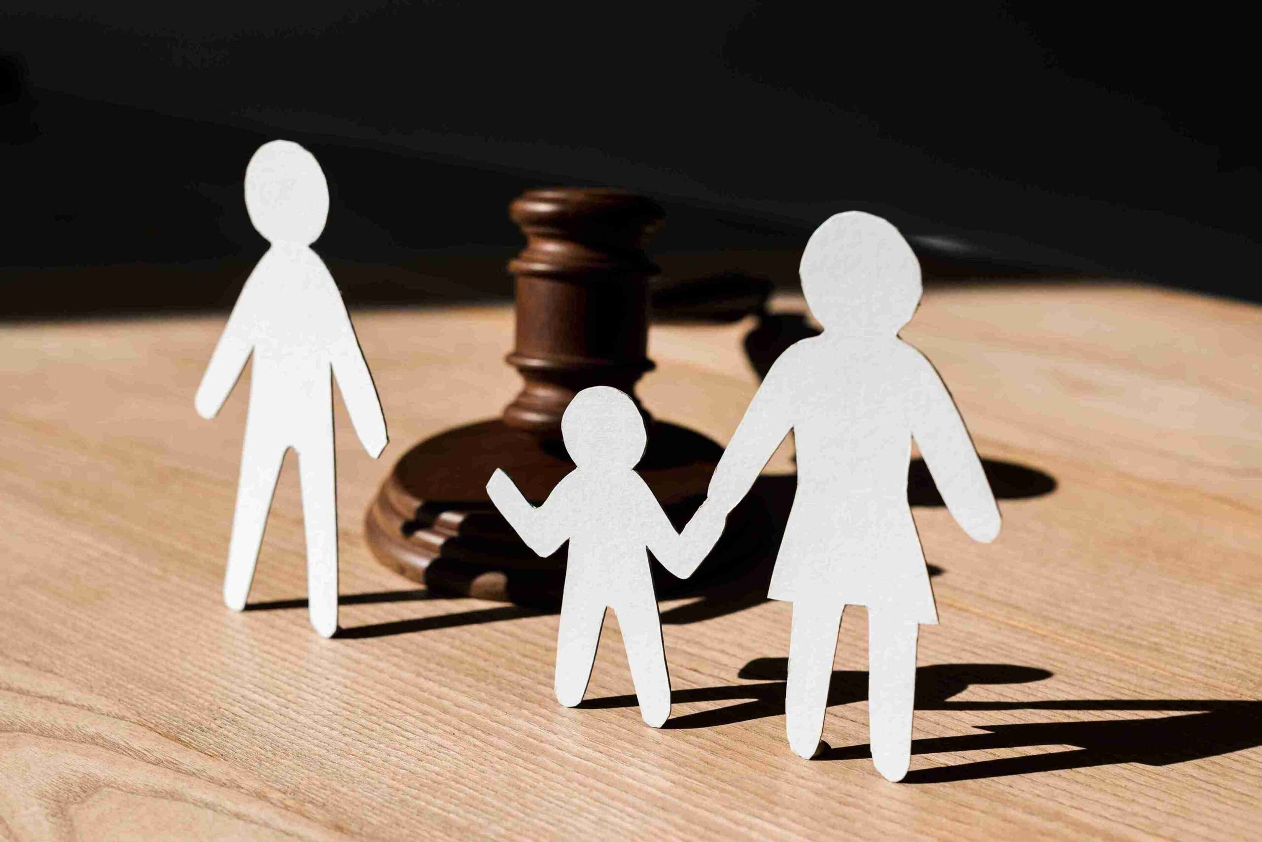 Family paper cutouts beside a gavel, representing experienced family solicitors handling child custody and child arrangements.