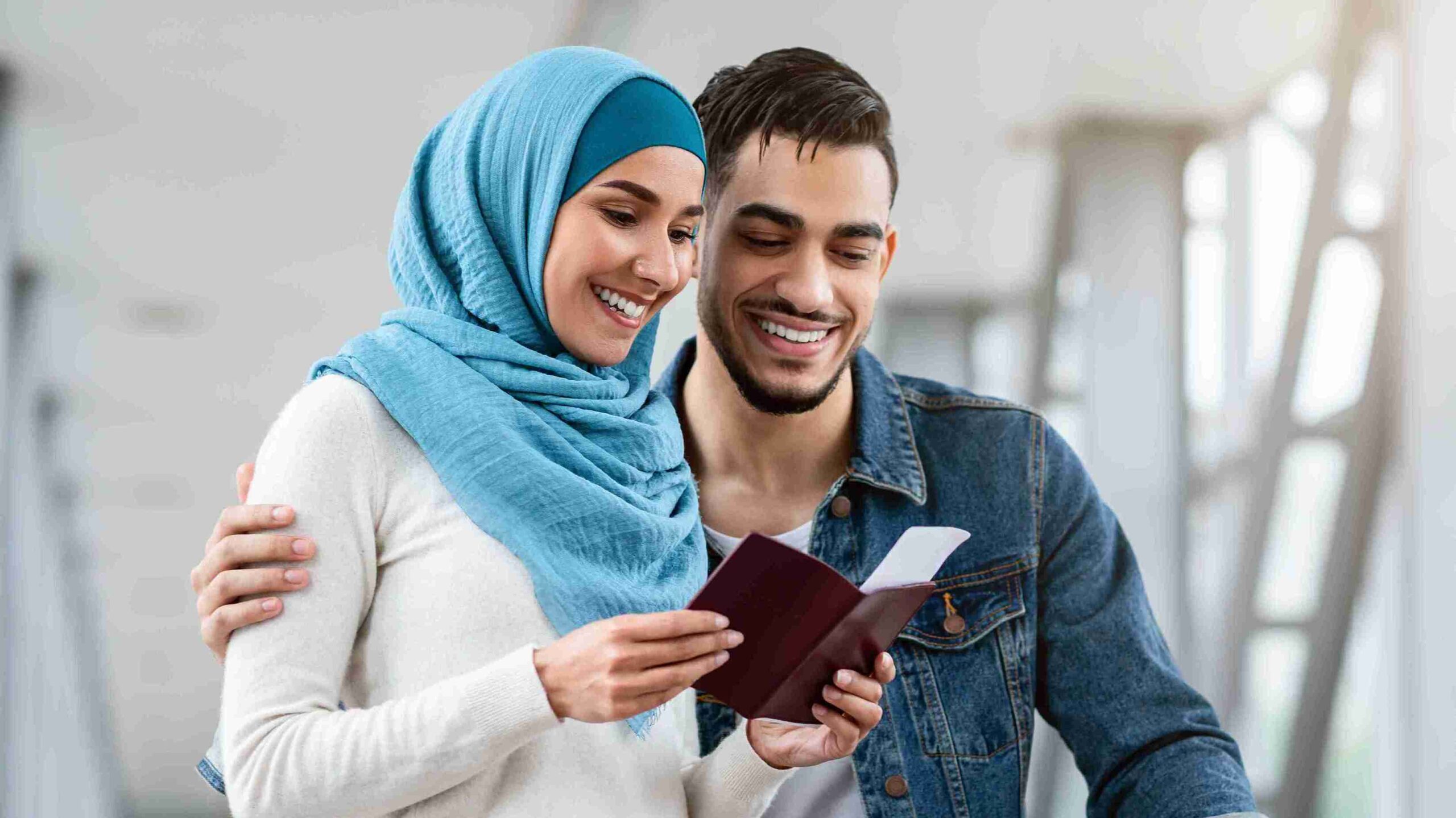 Smiling couple at an airport holding passport and ticket, representing expert support with spouse visa extension applications.
