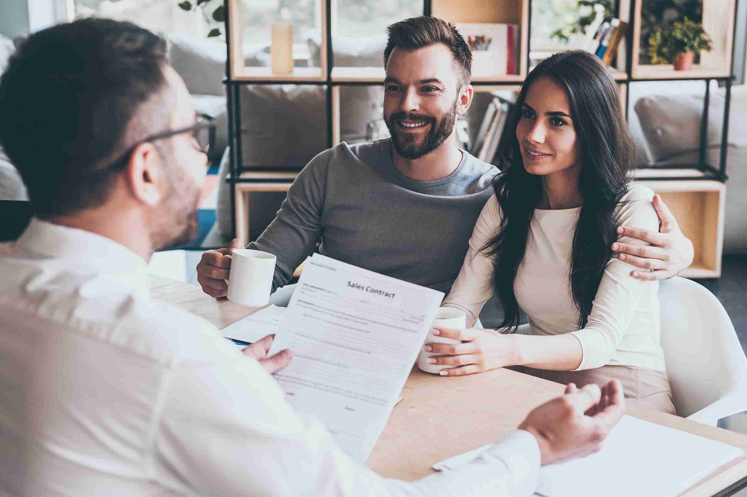 A couple sits at a table with coffee, reviewing a document about Morocco Spouse Visa guidance from solicitors.