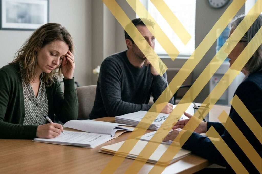 A professional divorce solicitor Manchester is consulting with a couple in a modern office setting, discussing the divorce proceedings and child arrangements.
