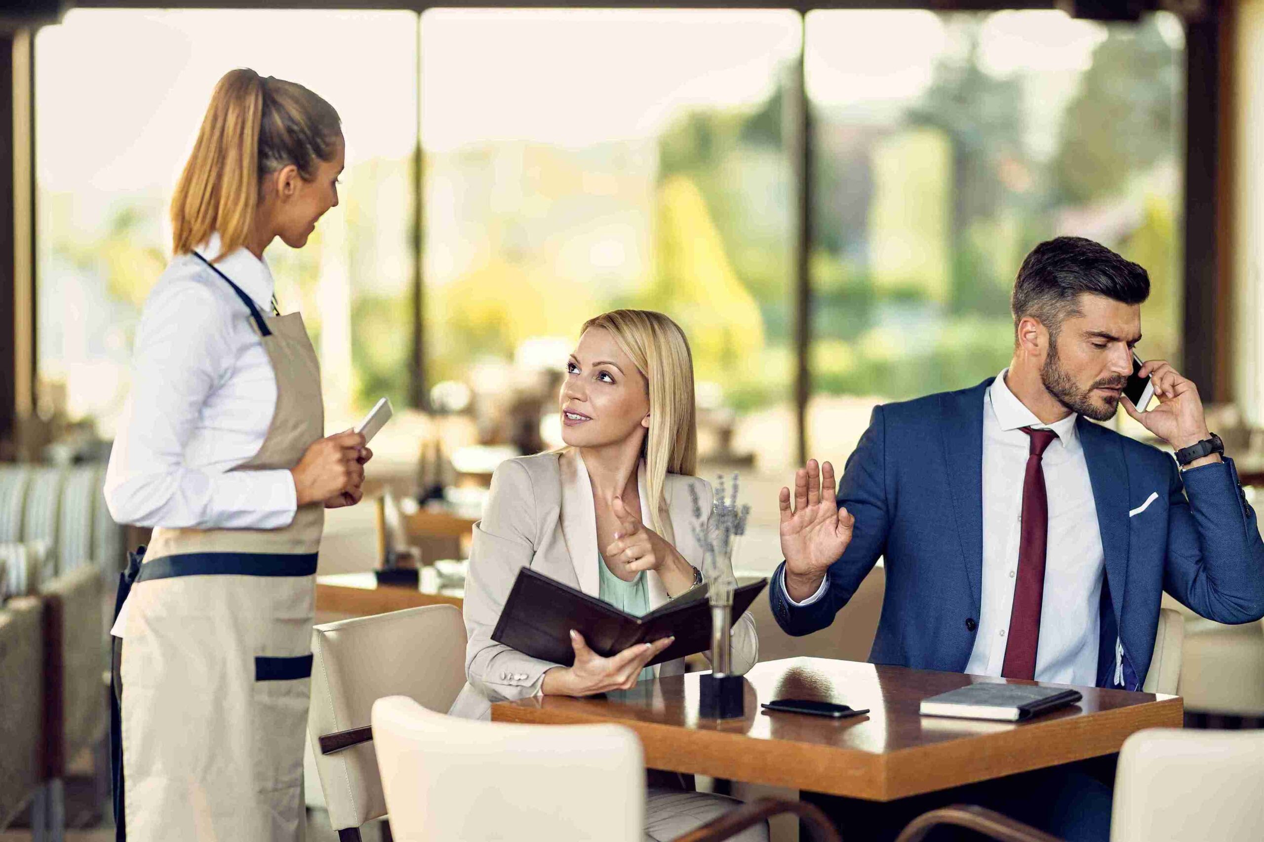 A man and woman in business attire engaged in a phone conversation, focused and discussing important matters
