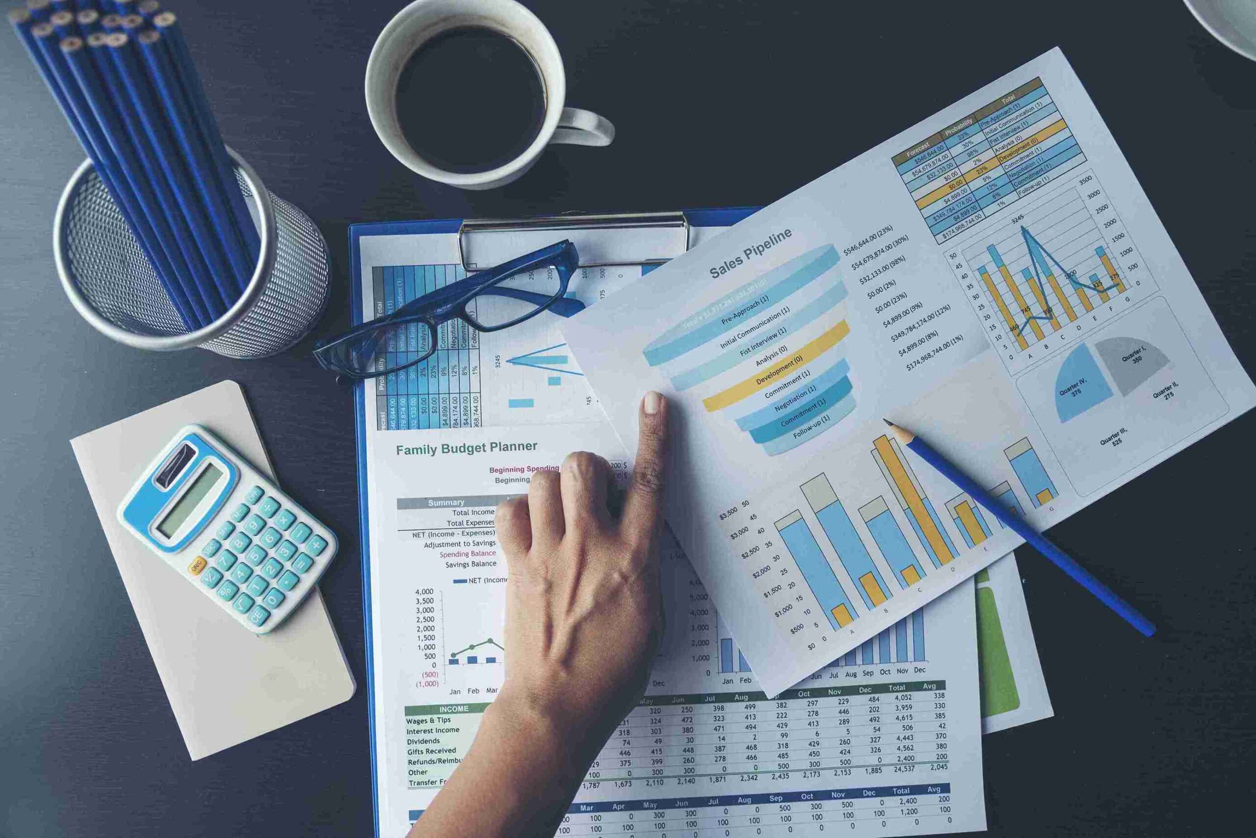 Person in suit analysing sales report with magnifying glass and calculator, representing protecting businesses, and finances from tax investigations.