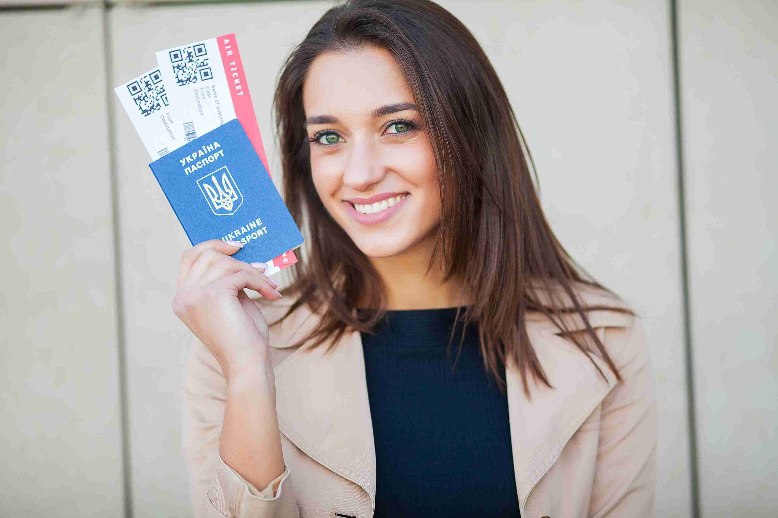 A smiling woman displays two passports, symbolizing her journeys and the diverse cultures she is ready to explore.