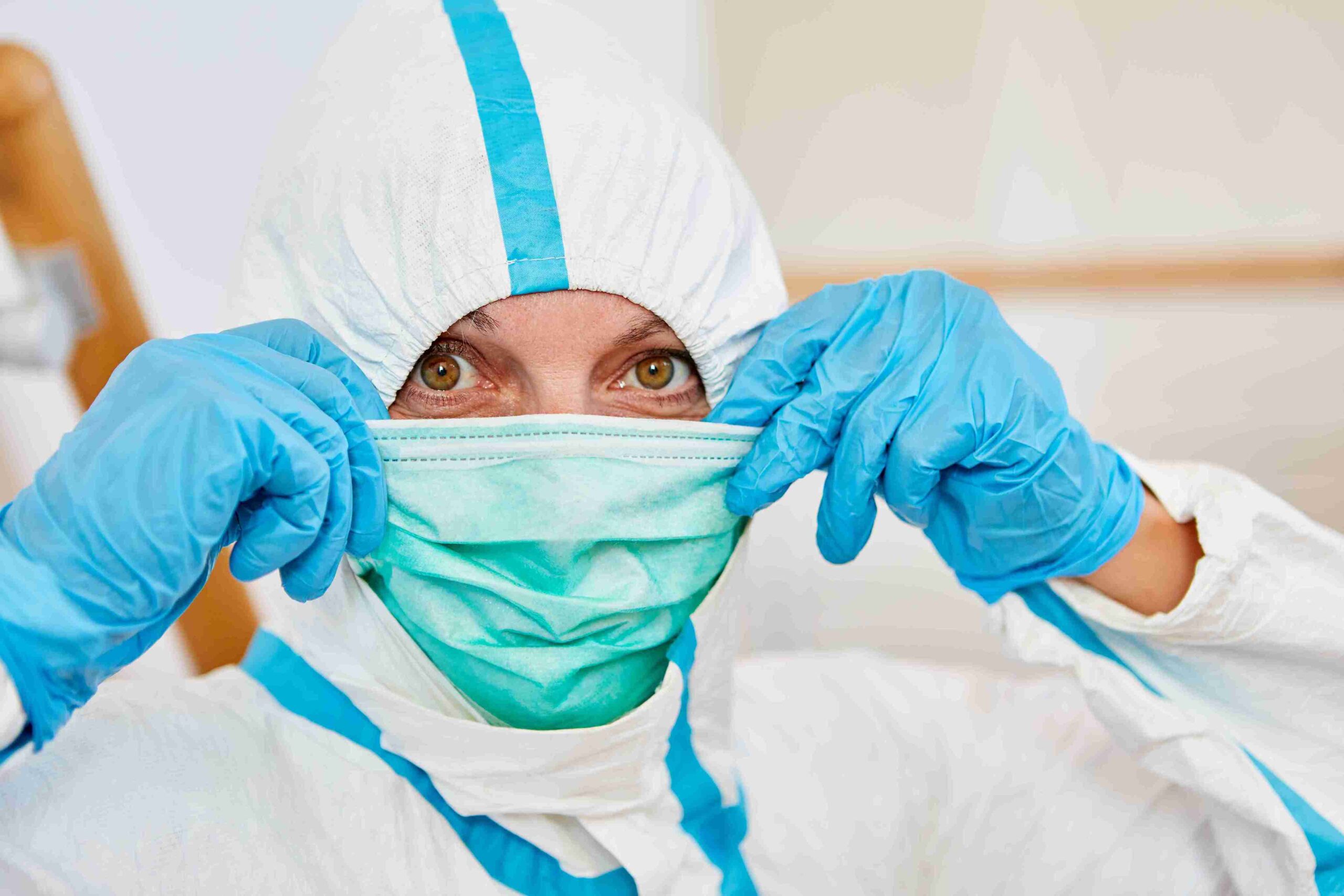 A woman wearing a protective suit and gloves, ready for a safe and secure task in a hazardous environment.