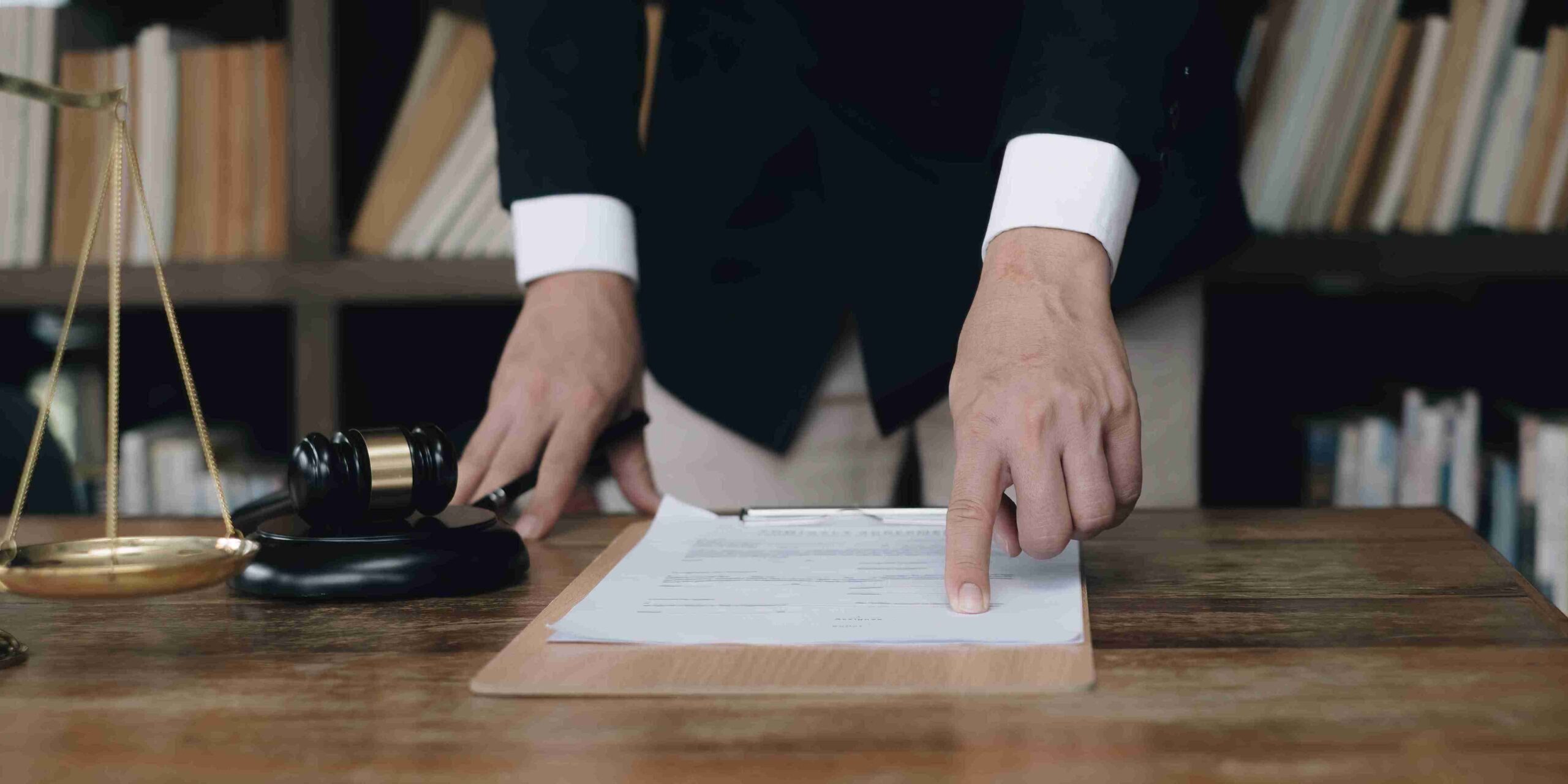 A person in a suit stands confidently, holding a piece of paper, possibly presenting important information.
