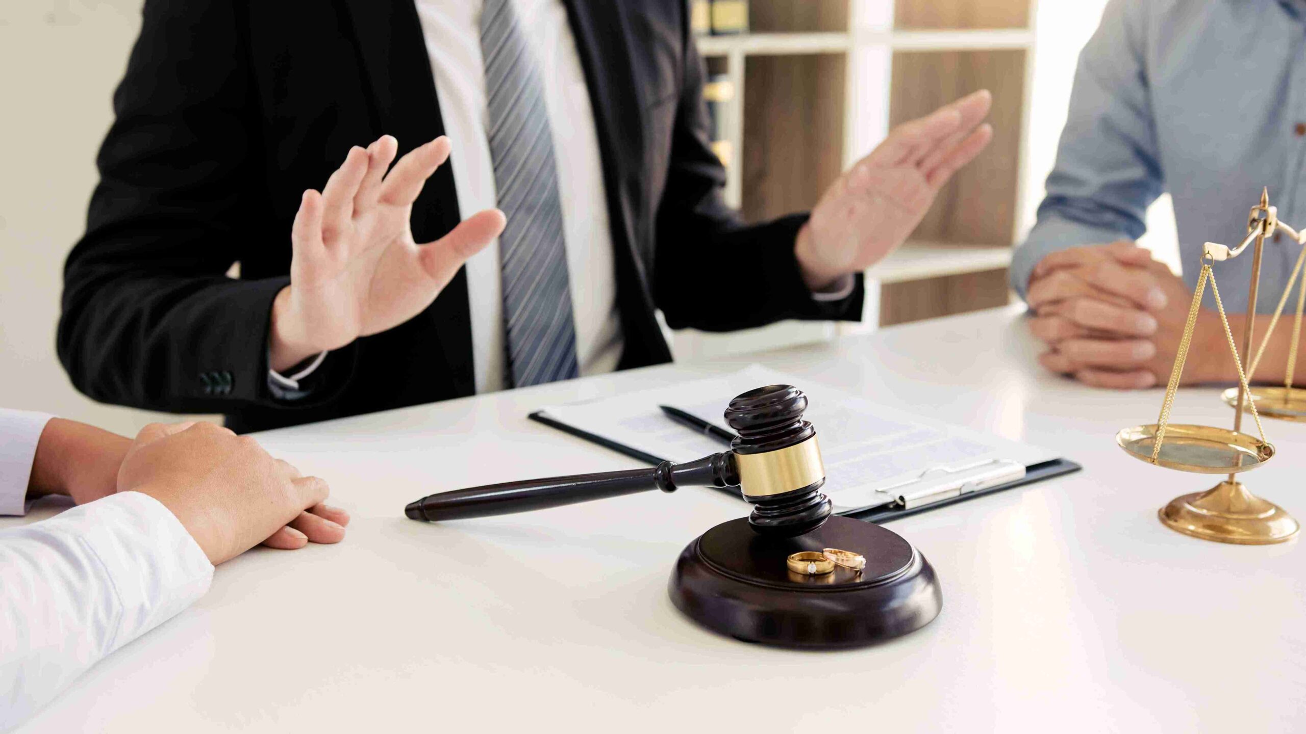 Wedding rings resting on a judge's gavel, symbolizing the union of marriage and legal agreements.