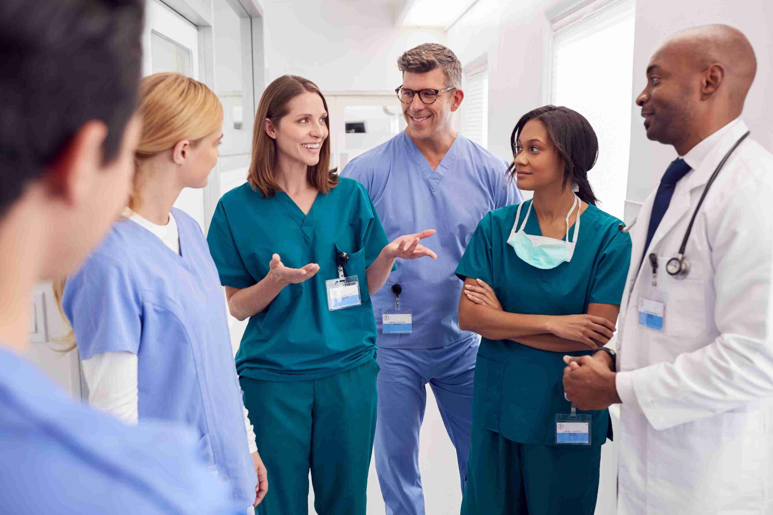 A group of doctors engaged in conversation, sharing ideas and discussing patient care in a hospital setting.
