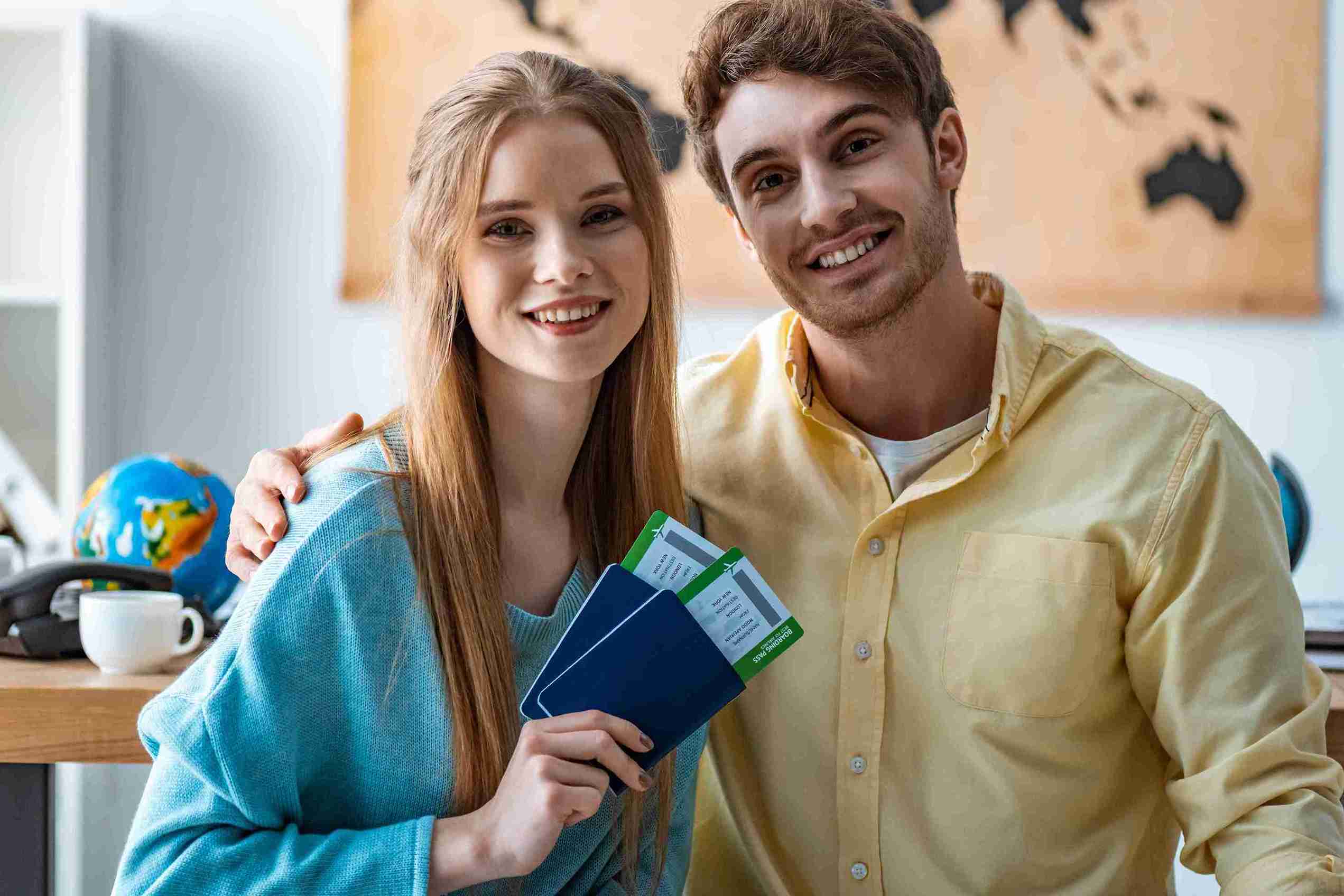 A couple joyfully displaying their passports, symbolizing their excitement for an upcoming trip.