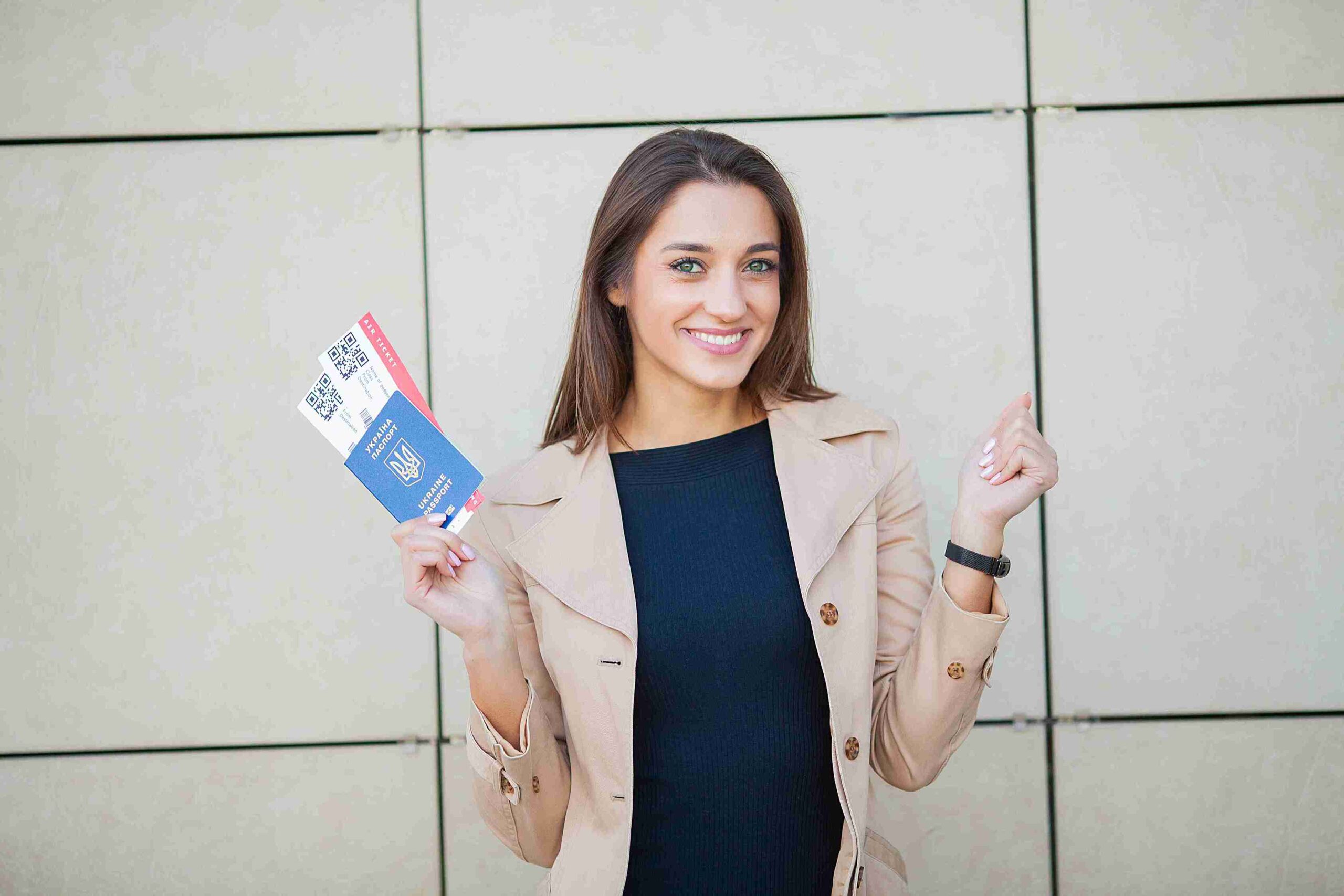 A woman holds a passport in one hand and a business card in the other, ready for her next professional journey.