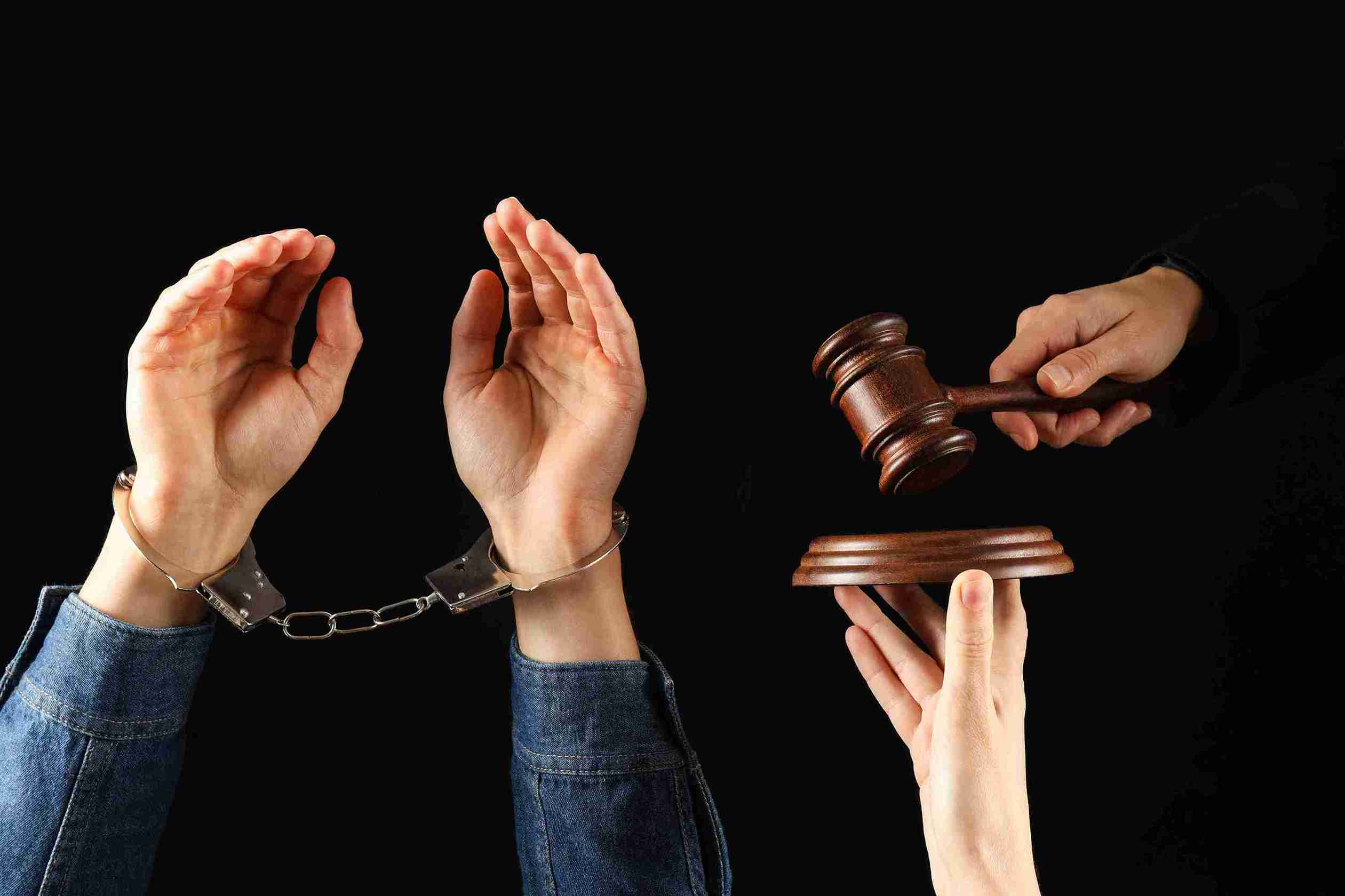 Hands holding a gavel and a hand with handcuffs, symbolizing justice and law enforcement