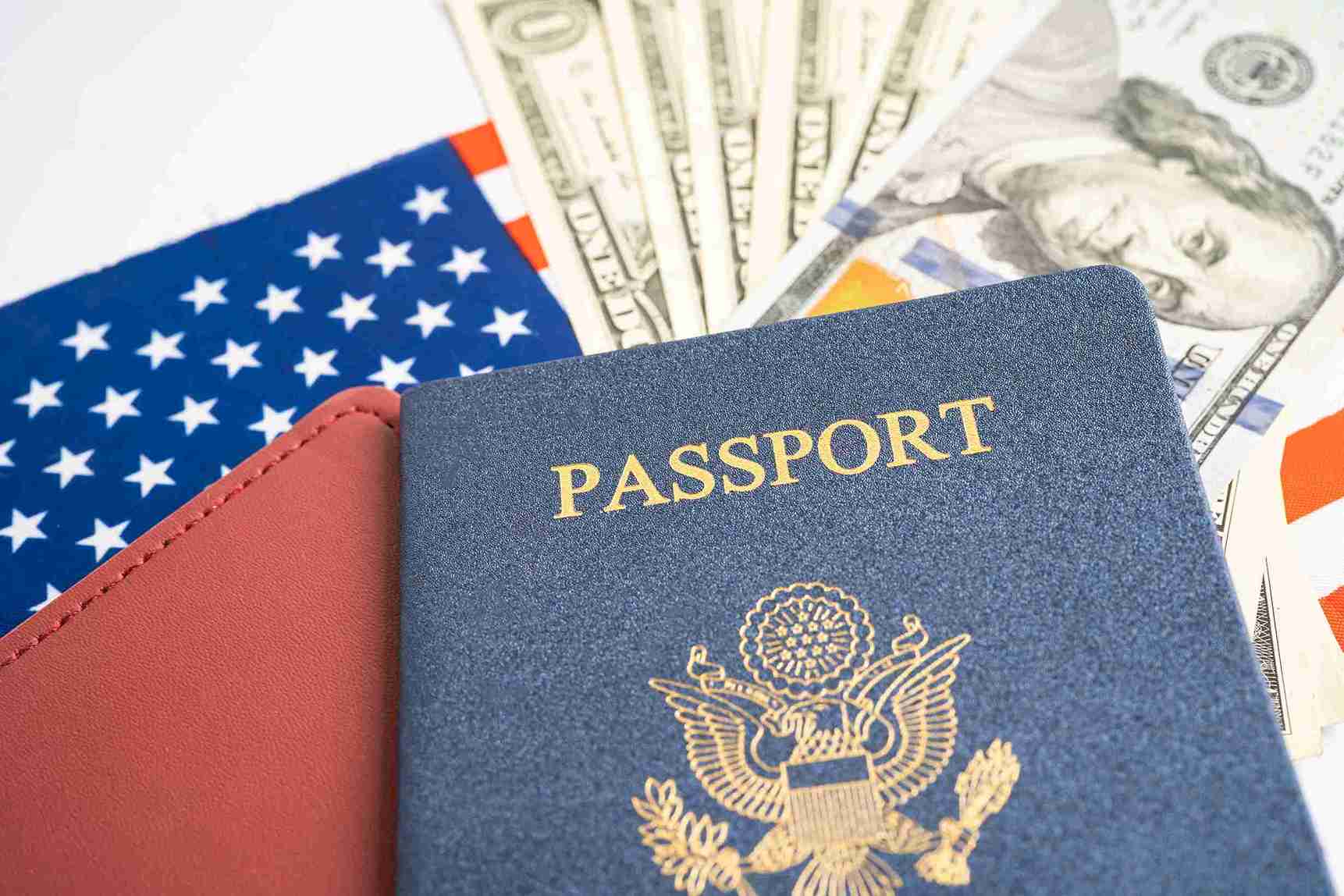 A passport alongside a stack of US dollars, symbolizing travel and currency exchange.