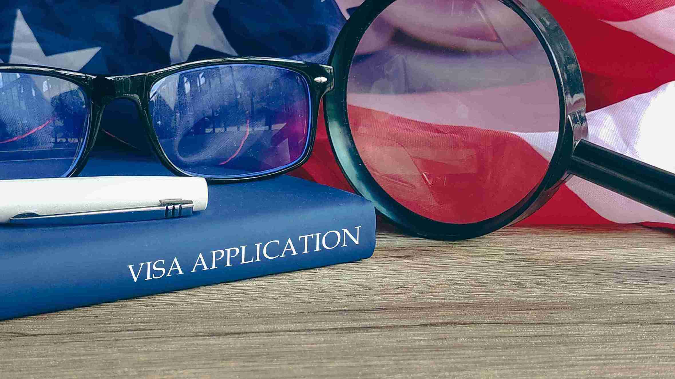A close-up of a completed visa application form for the USA, with personal details and official stamps visible.
