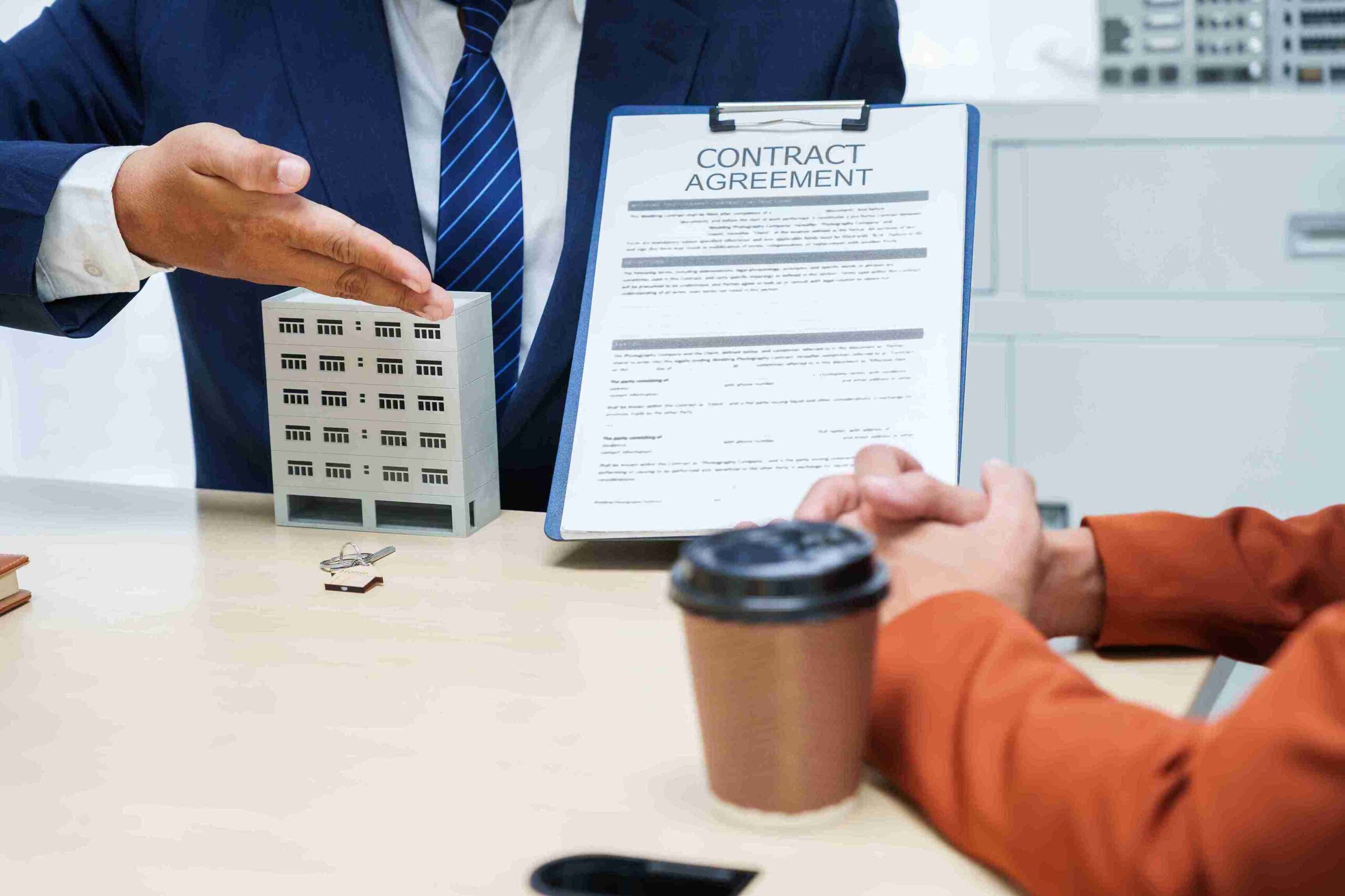 A man and woman sit at a table, reviewing a contract agreement together, focused and engaged in discussion.