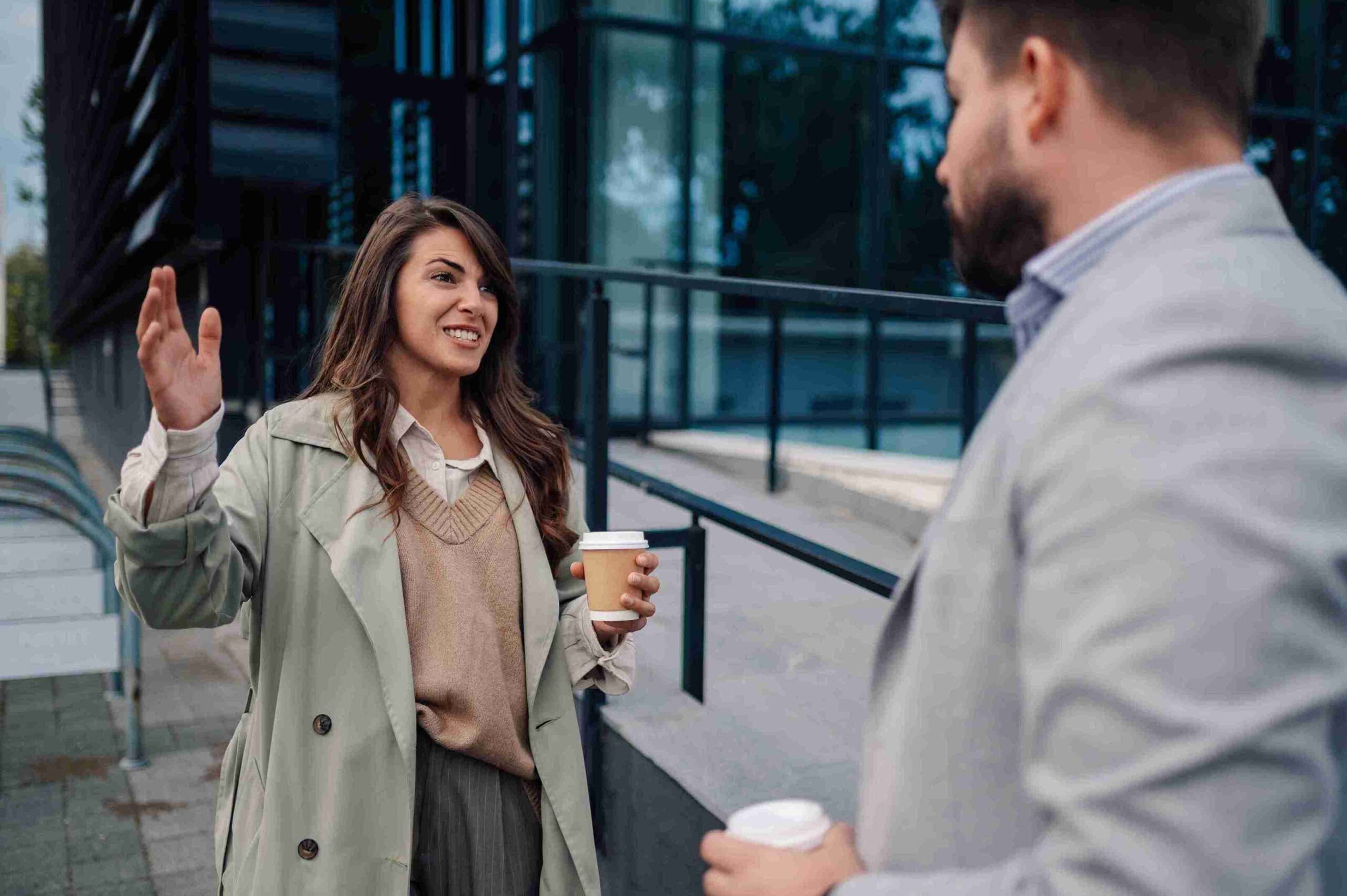 A man and woman engaged in conversation, smiling and sharing ideas in a friendly setting.