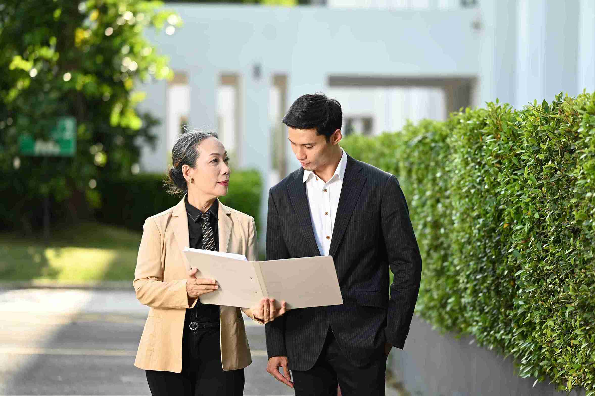 Asian business couple reviewing a business plan together in a modern office setting.