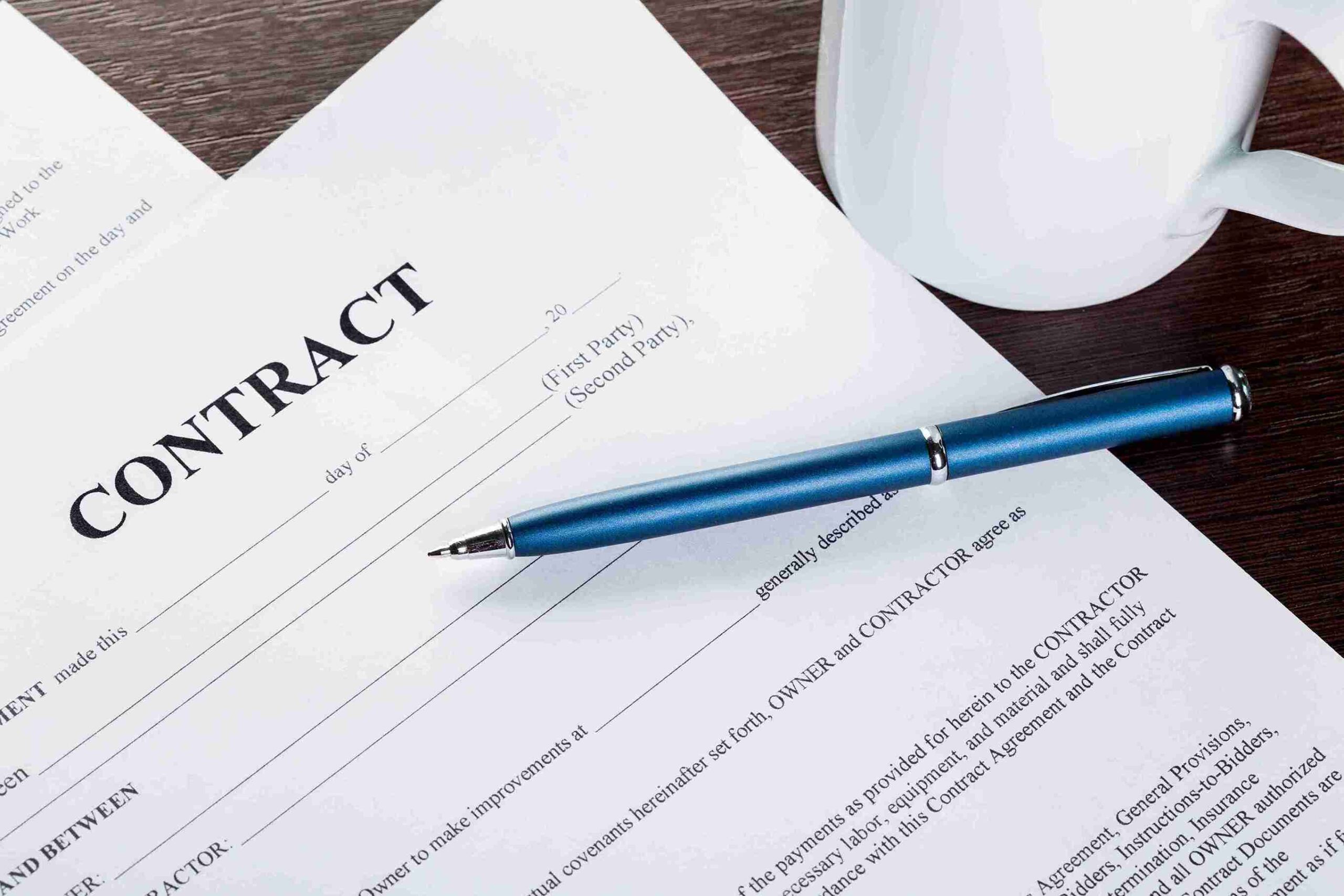 A collection of contracts and legal documents stacked on a desk, showcasing formal agreements and signatures.