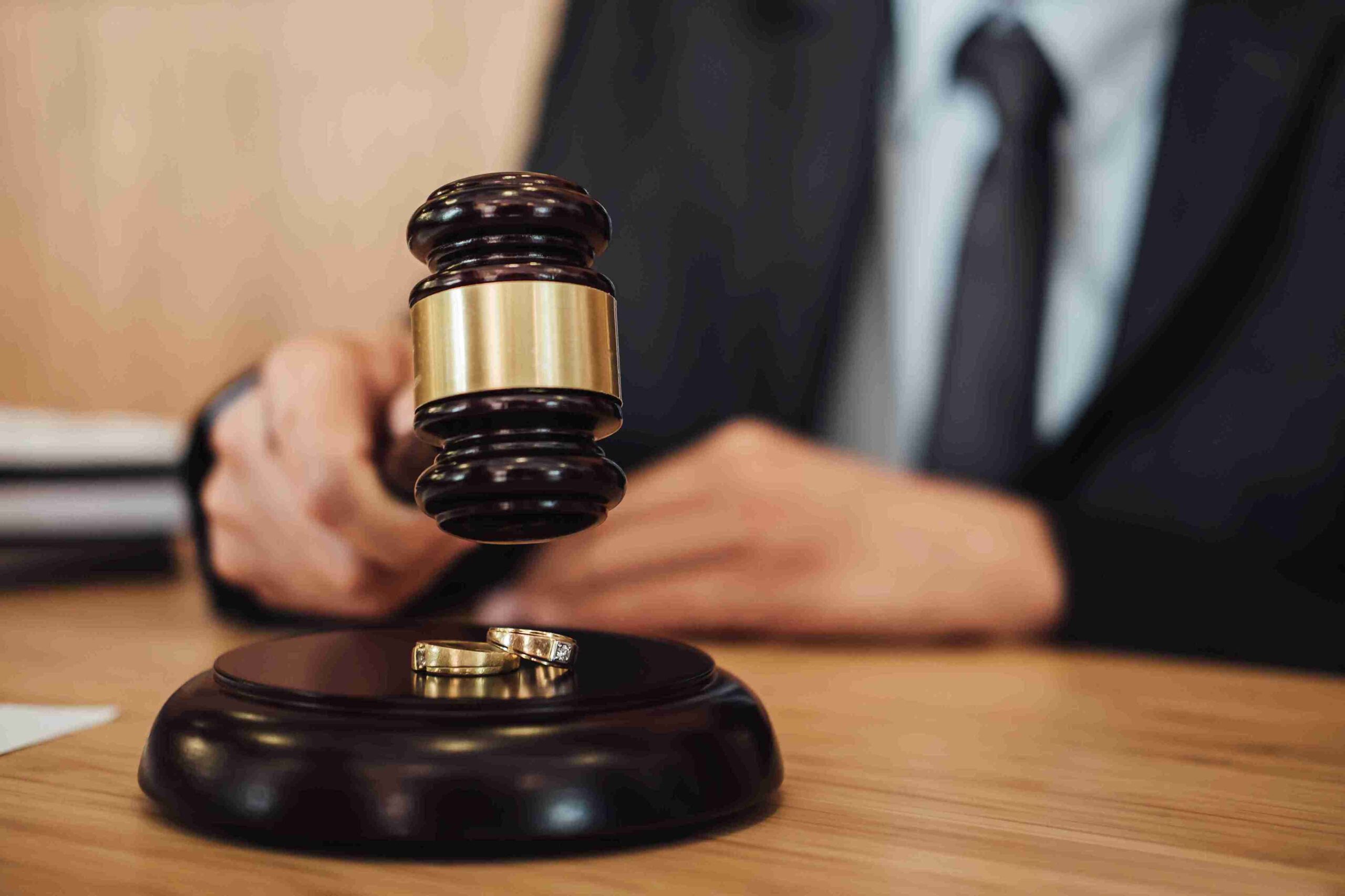 Wedding rings resting on a judge's gavel, symbolizing the union of love and law.