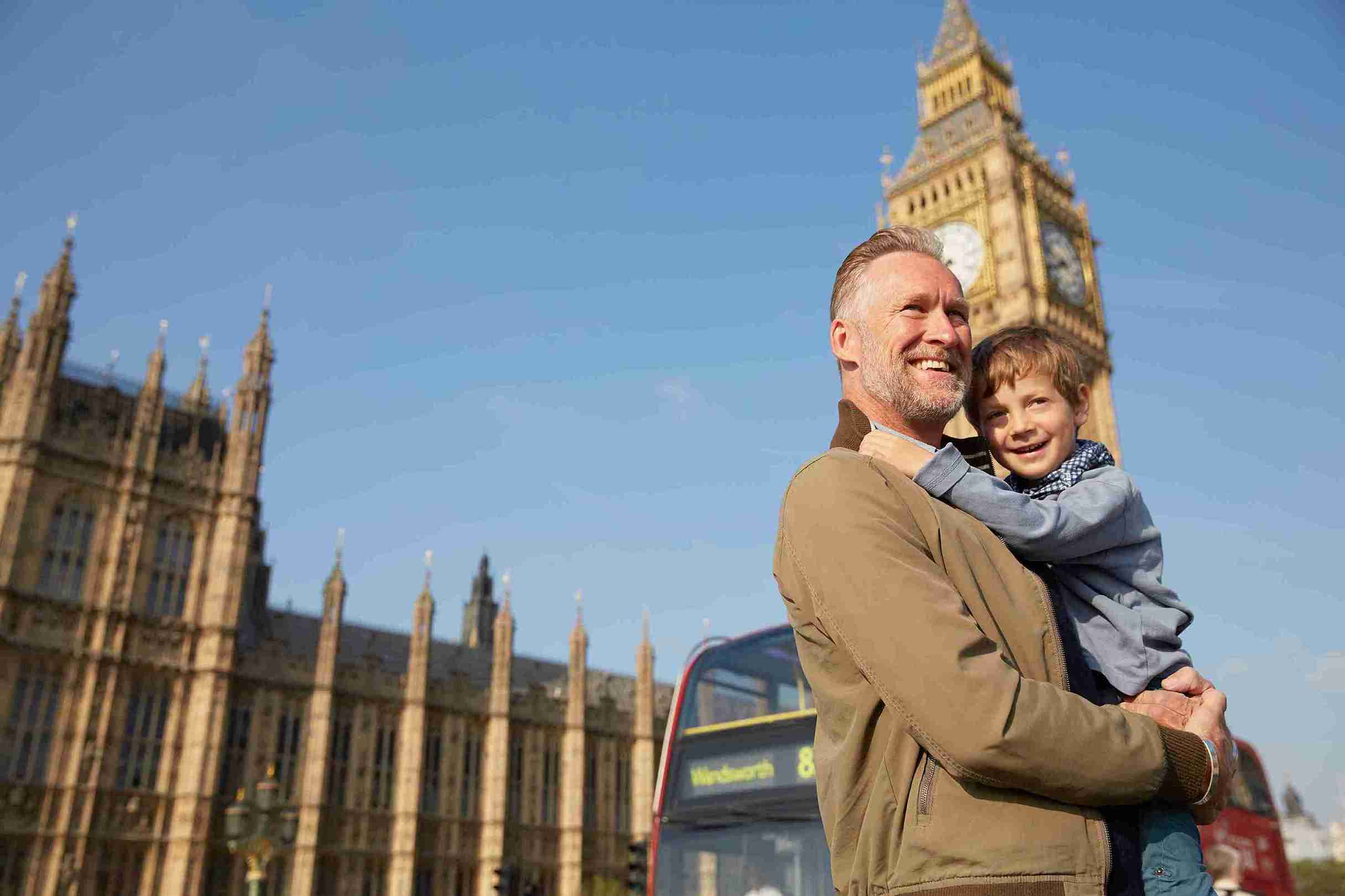 Father carrying son in front of big ben.