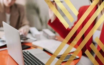 Blurred image of two professionals working on a laptop, representing high-skilled workers or planning immigration strategy for ILR Eligibility