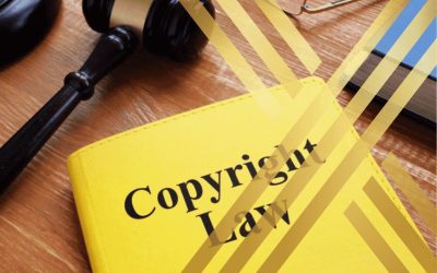 Gavel on a yellow book titled "Copyright Law," symbolizing legal enforcement of copyright protection.